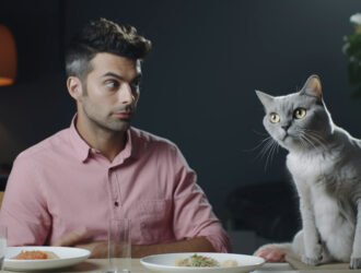 Boy sitting with his cat on a table.